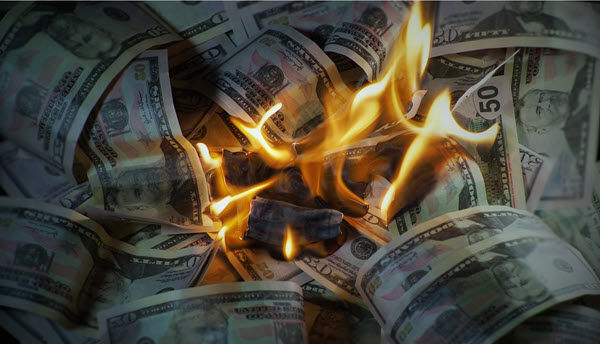 An image of burning money which represents the board and management’s inefficient use of owner assessments.
